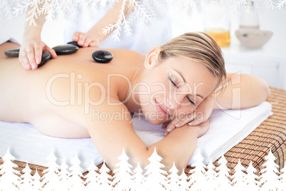 Pretty young woman receiving a massage with hot stone