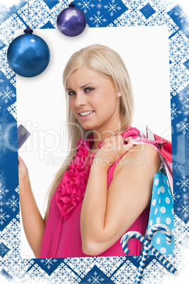 Composite image of blonde holding shopping bags and a card