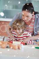 Composite image of nice mother and son baking in a kitchen