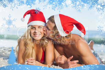 Man giving kiss to partner wearing christmas hats
