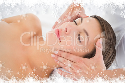 Attractive young woman receiving facial massage at spa center