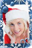 Composite image of young blonde woman putting on the santa claus hat