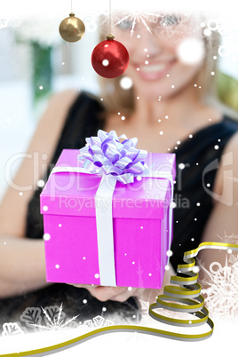 Blond woman opening a gift sitting on a sofa