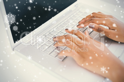 Close up on womans hands typing on her laptop