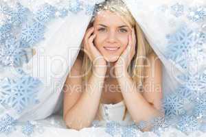 Smiling relaxed young woman lying in bed