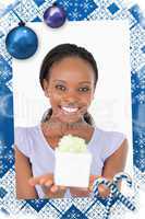 Composite image of close up of smiling woman holding a present a