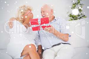 Composite image of old man offering a gift to the elderly woman