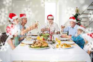 Composite image of family toasting wine while having christmas m