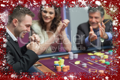 Composite image of people cheering man at craps game