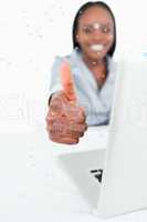 Composite image of portrait of a businesswoman using a laptop wi