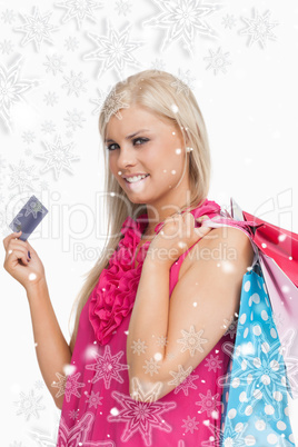 Composite image of blonde holding shopping bags and a card