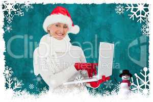 Composite image of festive woman holding laptop