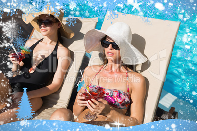 Women holding drinks by swimming pool