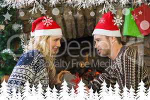 Man gifting woman in front of lit fireplace during christmas