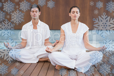 Attractive couple in white meditating in lotus pose