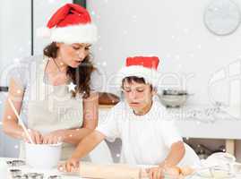 Composite image of mother and son preparing christmas biscuits t