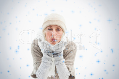 Mature woman in winter clothes blowing kiss