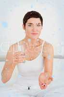 Composite image of young woman taking pills