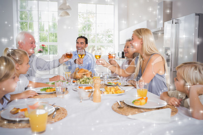 Composite image of adults raising their glasses at thanksgiving