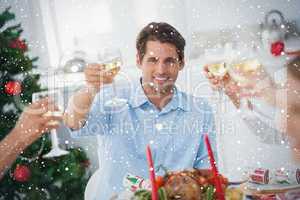 Composite image of family toasting at christmas dinner
