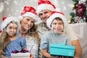 Family wearing christmas hat while holding presents