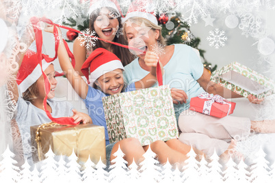 Composite image of happy family at christmas opening gifts toget