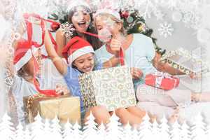 Composite image of happy family at christmas opening gifts toget
