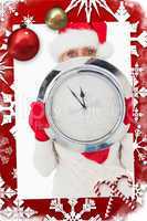 Composite image of festive woman looking at camera holding clock