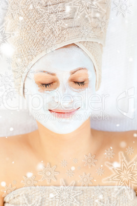 Cute young woman with closed eyes having white cream on her face