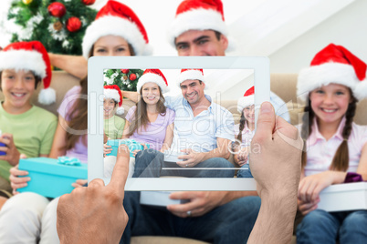 Composite image of hand holding tablet pc