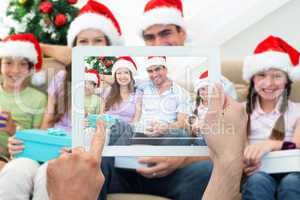 Composite image of hand holding tablet pc