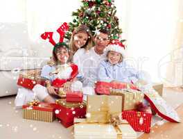 Composite image of happy family holding christmas gifts