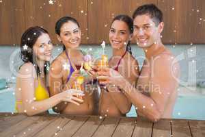 Cheerful people toasting drinks in the swimming pool