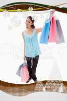 Composite image of portrait of a happy woman showing shopping ba