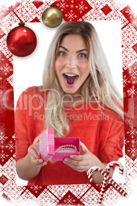 Composite image of surprised woman discovering necklace on a box