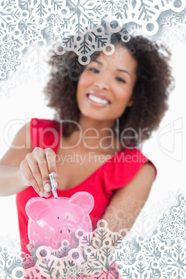 Composite image of money been put into a pink piggy bank