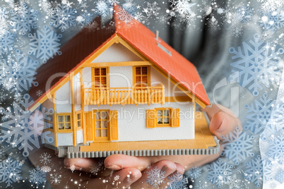 Hands showing a miniature model home