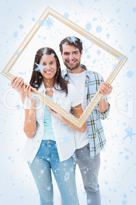 Happy young couple holding picture frame