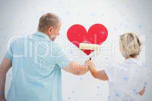 Happy older couple painting red heart