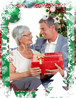 Composite image of senior man giving a christmas present to his