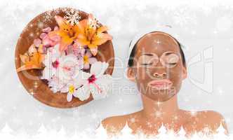 Composite image of smiling brunette getting a mud treatment faci