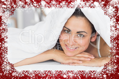 Smiling relaxed young woman lying in bed