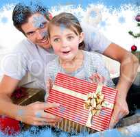 Happy little girl with her father receiving a christmas present