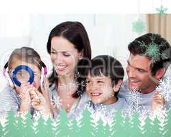 Composite image of happy family playing with a magnifying glass
