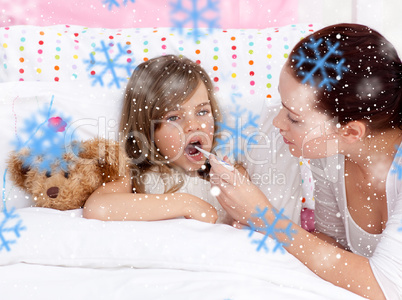 Composite image of mother taking her daughters temperature with