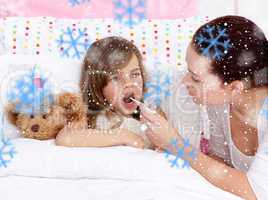 Composite image of mother taking her daughters temperature with