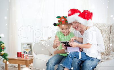 Mother and children looking at a calendar sitting on the sofa