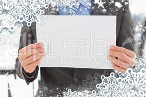 Composite image of businessman holding blank page
