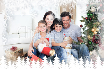 Composite image of happy family at christmas time holding lots o