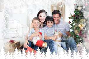 Composite image of happy family at christmas time holding lots o